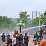 Polisi menyemprotkan water cannon ke arah massa aksi May Day di Jalan Pahlawan Semarang, Kamis (1/5/2025).