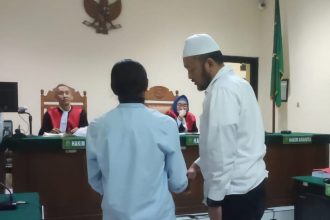 Aipda Robig (berprci), polisi penembak siswa, menyalami ayah korban penembakan, dalam sidang di PN Semarang, Selasa (6/5/2025).