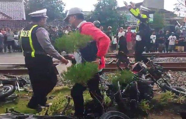Petugas saat mengevakuasi korban dan kendaraan pasca kecelakaan maut di Jalur Perlintasan Langsung Kereta Api di wilayah Desa/ Kecamatan Barat, Kabupaten Magetan, Senin (19/5/2025) siang.