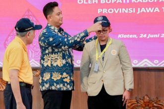 Bupati Klaten Hamenang Wajar Ismoyo mengenakan topi sebagai tanda penerimaan kepada mahasiswa KKN-PPM UGM.