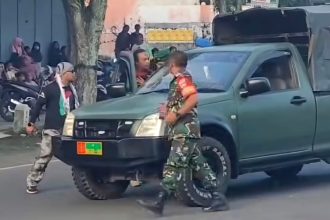 Anggota ormas GPK (kiri) tampak emosi kepada anggota TNI pengemudi mobil OZ. (tangkapan layar dari media sosial)