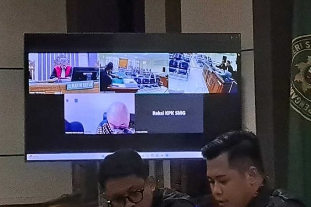 Terdakwa Rachmat Utama Djangkar (kepala pelontos di layar monitor) terlihat tertuntuk menyeka air mata saat membaca nota pembelaan sidang yang berpusat di Pengadilan Tipikor Semarang, Rabu (11/6/2025). (bai)