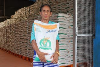 Foto ilustrasi seorang warga mengangkat sekarung beras di gudang Bulog. Awas! Beras yang anda konsumsi beras oplosan yang dikata preimum ternyata kwalitasnya tidak sama. Jangan heran jika dimasak mudah basi dan tidak tahan lama.