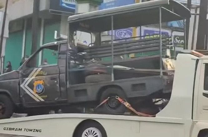 Mobil patroli polisi yang dirusak massa aksi solidaritas driver ShopeeFood dievakuasi menggunakan towing.